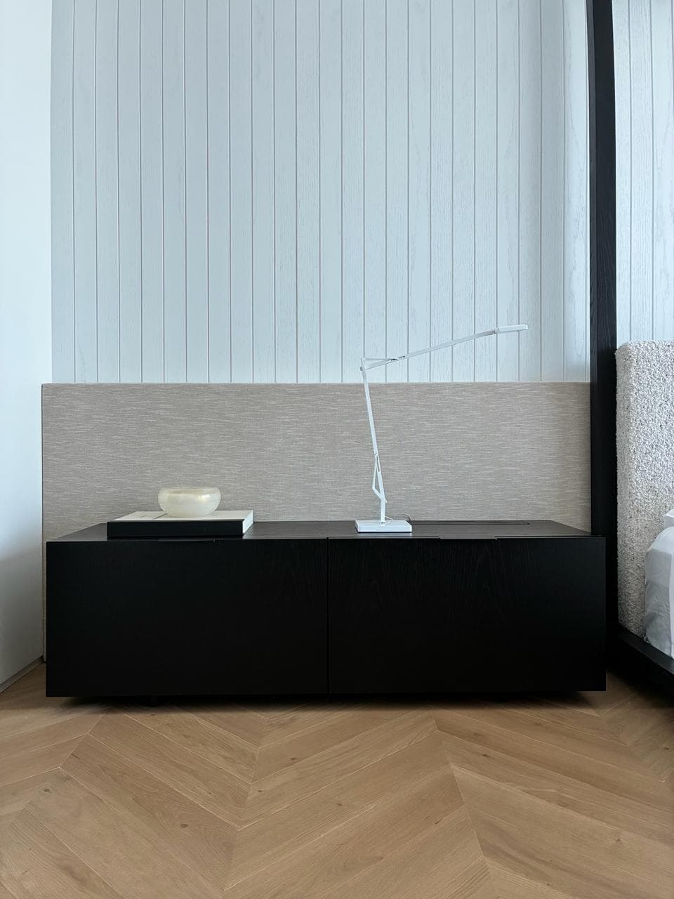 A study in cream matte lacquer with a corner run of lit shelves above a continuous desk and base cabinets.